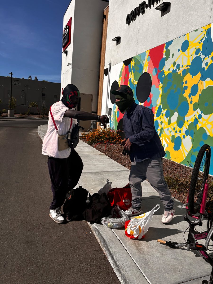Outreach on a city sidewalk next to a colorful mural