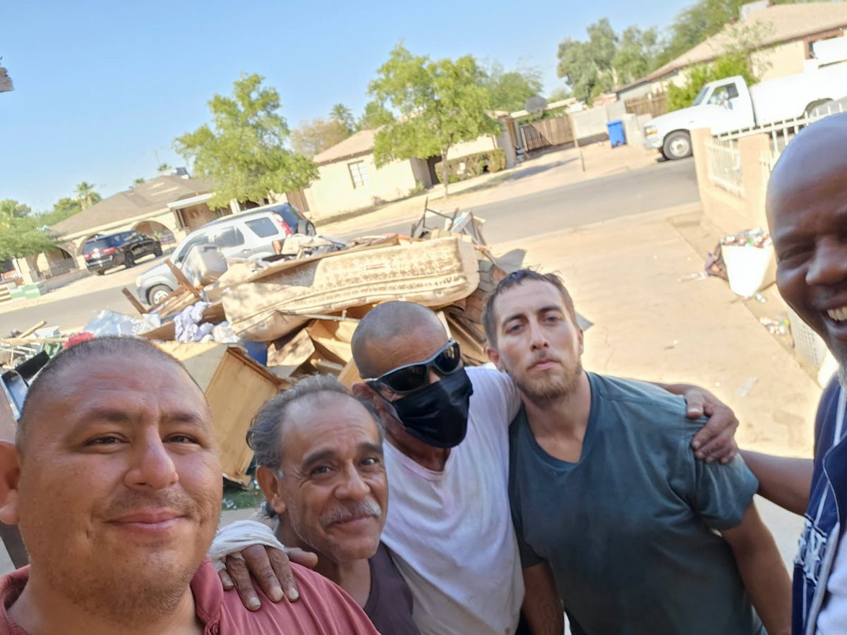 A group of men posing together during a neighborhood clean-up