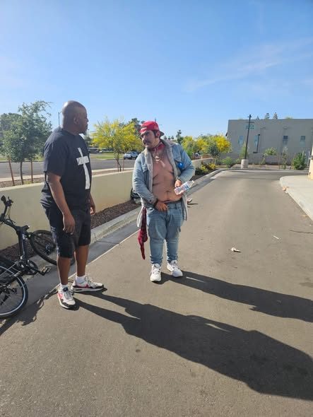 A volunteer talking with a neighbor on the sidewalk